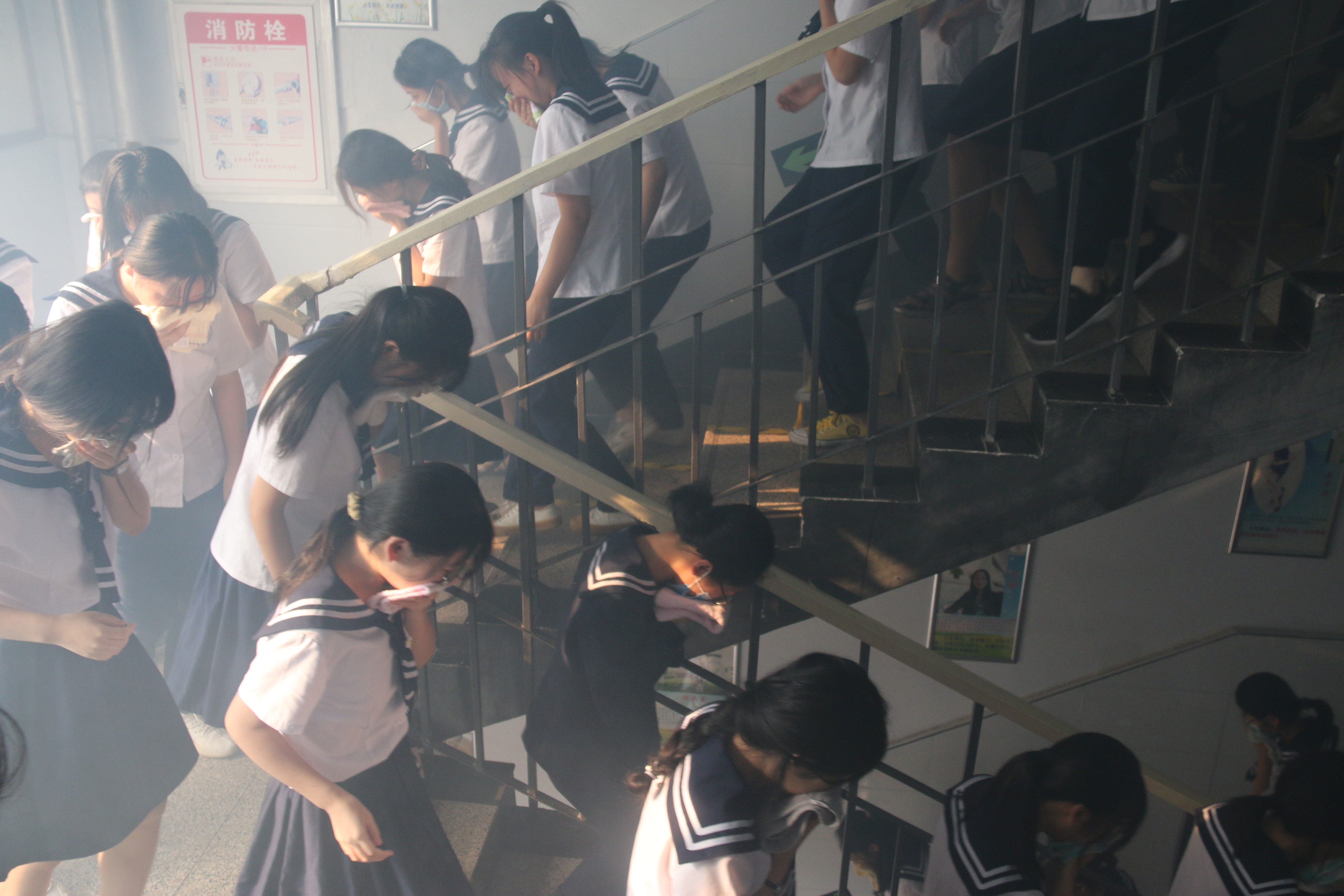 图|学生有序低腰捂鼻下楼